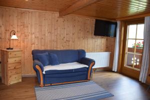 MörtschachFerienwohnung Suntinger的客厅配有蓝色的沙发和电视