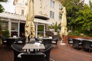 萨格勒布维拉蒂娜酒店的一个带桌椅和遮阳伞的户外庭院。