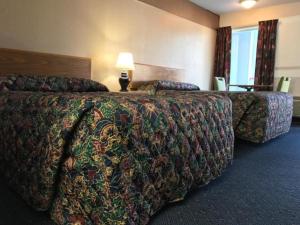 麦岭美国汽车旅馆的酒店客房设有两张床和一张带台灯的桌子。