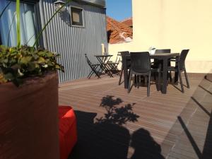 波尔图Oporto Downtown Flats的露台配有椅子和桌子,甲板上配有桌子