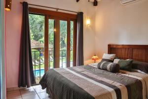 塔马林多马孔多别墅的一间卧室设有一张床和一个大窗户