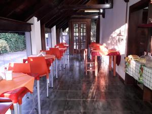 伊瓜苏港Petit Hotel Caraguata的一间空餐厅,配有红色的桌椅