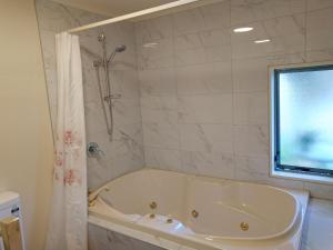 基督城阿尔卡拉汽车旅馆 的带窗户的浴室内的白色浴缸
