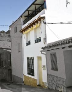 Puebla de BenifasarLa CasetA的白色的建筑,设有门和阳台