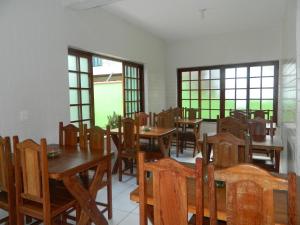 帕拉蒂Pousada Flor de Paraty的用餐室设有桌椅和窗户。
