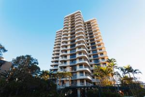 黄金海岸卡普里柯尼亚公寓的一座高大的建筑,前面有棕榈树