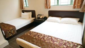 香港比比旺角宾馆的酒店客房设有两张床和窗户。