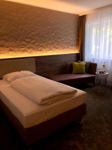 莱因费尔登-埃希特尔丁根埃姆帕克酒店的一间卧室配有一张床和一个沙发