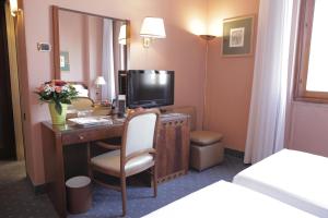 米兰布里斯托酒店的酒店客房设有一张书桌,电视