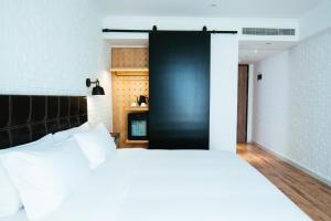 苏州欣得酒店留园虎丘店的卧室配有白色的床和黑色的门