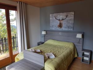 拉博莱讷韦聚比舍莫阿酒店的卧室配有一张床,墙上挂着鹿