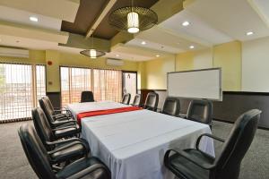 宿务Express Inn Cebu Mabolo的一间会议室,配有桌椅和屏幕