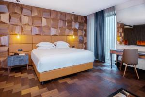 普里什蒂纳翡翠酒店的酒店客房配有一张床、一张书桌和一张书桌。