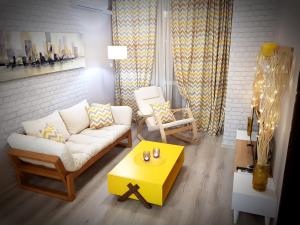 普罗夫迪夫Best Guest Apartments的客厅配有白色沙发和黄色桌子