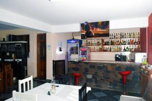 圣菲利佩Hotel Miramar Fogo Brava的餐厅设有酒吧,墙上配有电视。