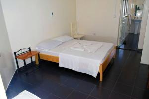 圣菲利佩Hotel Miramar Fogo Brava的一间卧室配有一张带白色床罩和桌子的床。