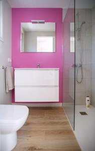 皮内达德马尔Bellsol Rooms的浴室设有白色卫生间和粉红色的墙壁。