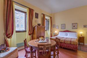 佛罗伦萨卡萨德尔嘉宝 - 豪华客房和套房酒店的酒店客房配有一张床铺、一张桌子、一张床铺和一张桌子。