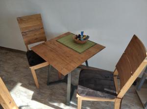 斯图加特Lovely Studio in Cannstatt的一张木桌,上面放着一碗笔和一把椅子
