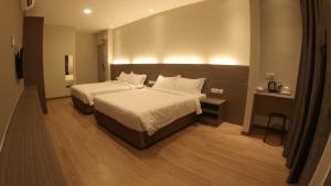 瓜拉立卑U Design Hotel Kuala Lipis的酒店客房,配有两张带白色床单的床