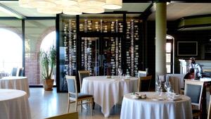 塞拉伦加达尔巴托塔弗吉尼亚安蒂科博德雷酒店的一间设有白色桌椅的餐厅,并提供葡萄酒瓶