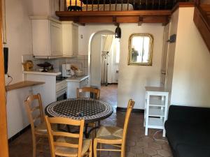 波克罗勒岛Maison de pêcheur à Porquerolles的厨房以及带桌椅的用餐室。