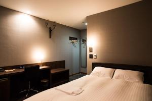 增田Hotel Daiei Masuda的酒店客房配有一张床、一张书桌和一张书桌。