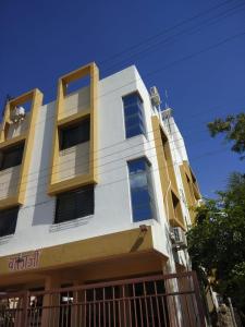 潘达尔普尔Balaji Lodging的白色和黄色的建筑,前面有栅栏