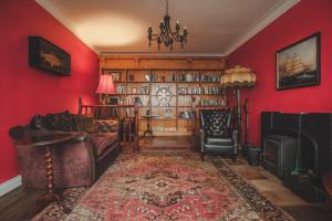 罗西斯波因特Sligo Bay Lodge的客厅设有红色的墙壁、沙发和壁炉