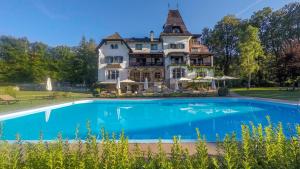 格绍兰德豪斯科勒酒店的一座大房子,前面设有一个游泳池