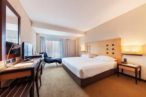 法蒂玛法蒂玛勒克斯酒店的酒店客房配有一张床、一张书桌和一台电视。