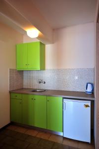 瓦西里亚斯vassilias beach hotel的厨房配有绿色橱柜和水槽