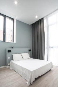 里尔NOCNOC - La Villa Cachee的卧室设有白色大床和窗户。
