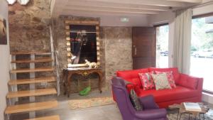 Corras de la PuenteCasas La Xiuca的客厅设有红色的沙发和壁炉
