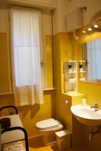 佛罗伦萨Renovated Central Suites的黄色的浴室设有卫生间和水槽