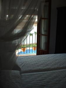 阿兹纳尔卡扎尔奥提格庄园酒店的一间卧室配有一张床,享有游泳池的景色