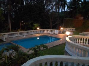 皮拉卡亚Pousada Casa Amarela的游泳池在晚上围着围栏