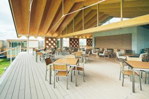 鹤冈市Shonai Hotel Suiden Terrasse的一间带木桌和椅子的餐厅以及甲板