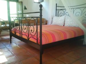 尼哈尔Hotel Rural Cortijo La Alberca的一间卧室配有一张黑色床和色彩缤纷的被子