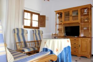 阿洛拉Casa Paquita Y Telesforo的客厅配有两把椅子和电视