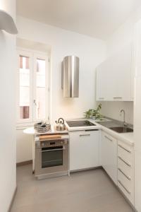 罗马Margana Tower的白色的厨房设有水槽和炉灶。