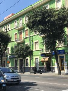 卡利亚里Millefiori的一座绿色建筑,前面有停车位