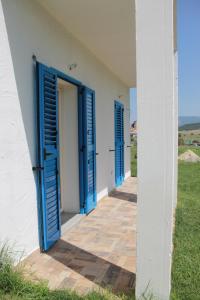 皮希纳斯S'Olivariu Village Affittacamere的白色建筑上的一排蓝色门