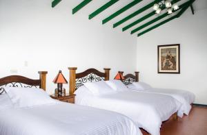 亚美尼亚瓦尔帕莱索芬卡酒店的白色客房内的两张床,配有白色床单