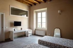 达尔米内B&B Dimora De Roteris的一间卧室设有两张床、一张桌子和一个窗口。