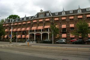 阿姆斯特丹阿姆斯特丹马诺尔酒店的街道上一座红遮篷的大型砖砌建筑