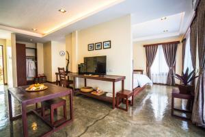 卢纳将军城Retreat Siargao Resort的酒店客房带一张床、一张桌子和椅子