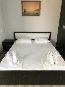 古达乌塔Guest House Palmovaia gavan的一张带白色床单和毛巾的床