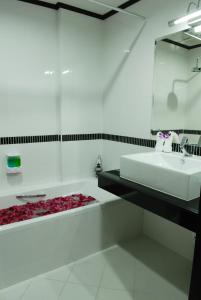 查汶First Residence Hotel的白色的浴室设有水槽和浴缸。
