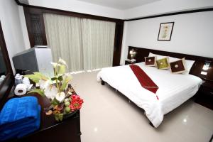 查汶First Residence Hotel的卧室里有一床,鲜花盛开